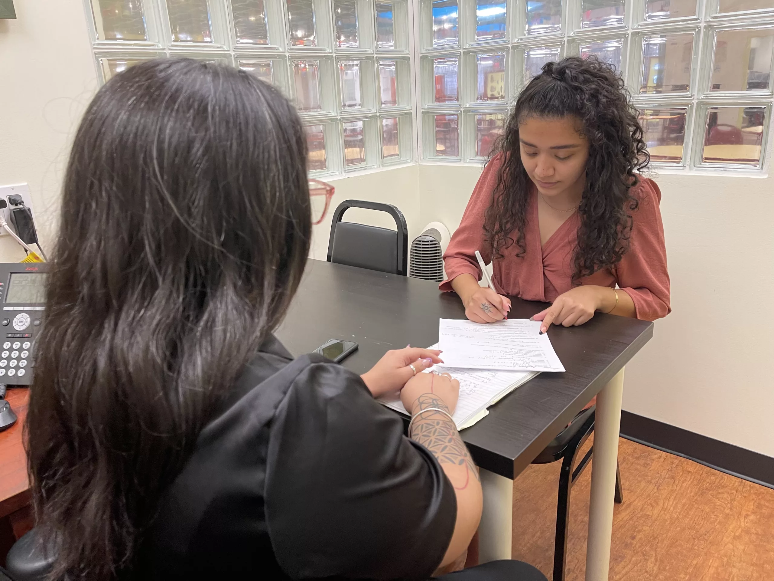 Women filling out documentation with a legal consultant