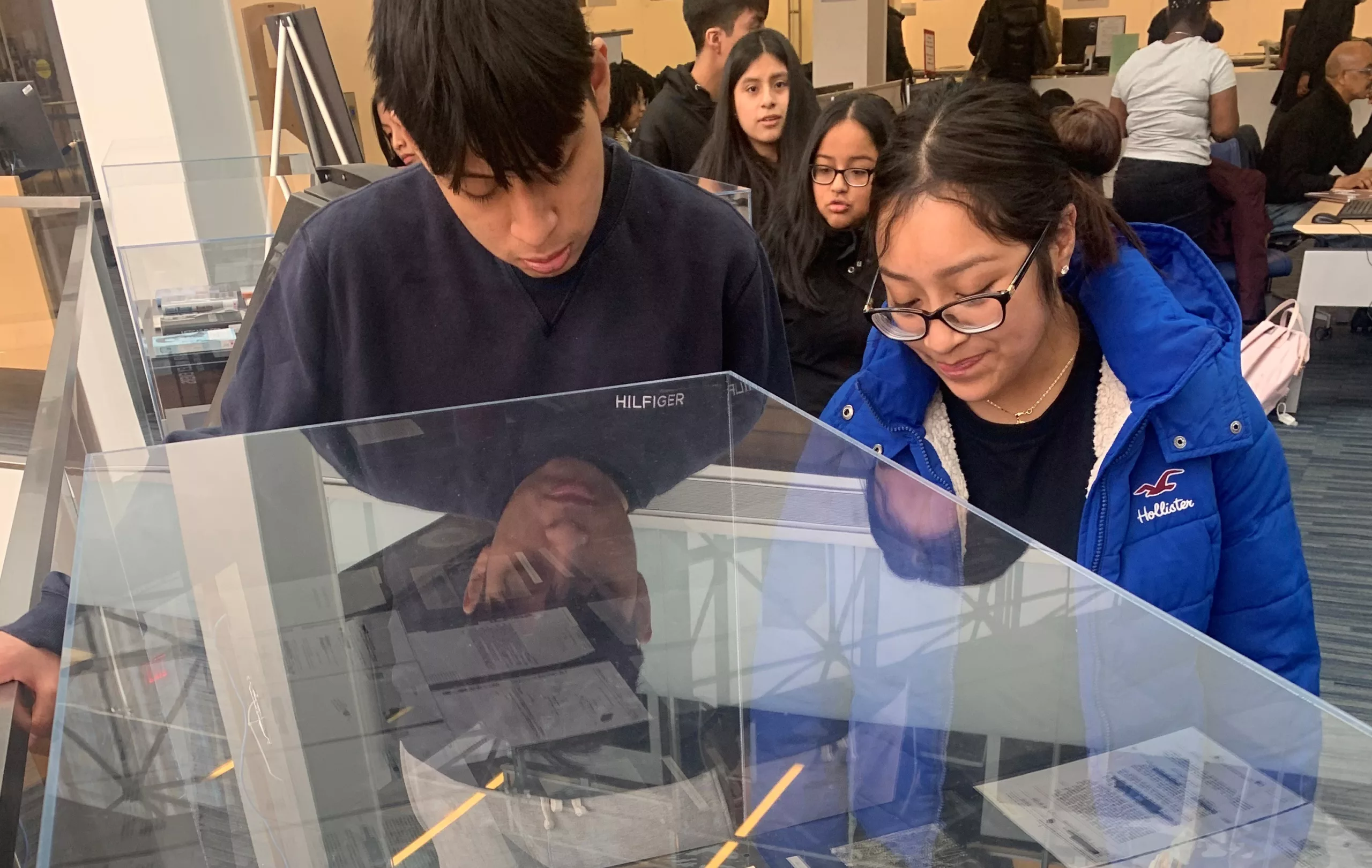 Students on a college trip to Medgar Evers look at historical documents.